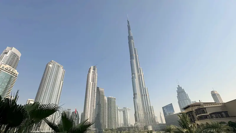 Burj Khalifa and the Downtown Dubai towers rising above palm trees on a clear day